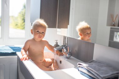 Bebek lavaboda banyo yapıyor. Çocuk köpük ve sabun Bubbl ile oynuyor