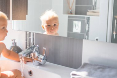 Bebek lavaboda banyo yapıyor. Çocuk köpük ve sabun Bubbl ile oynuyor