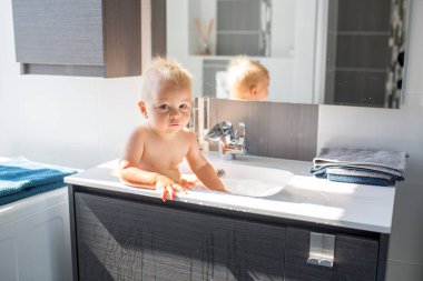 Bebek lavaboda banyo yapıyor. Çocuk köpük ve sabun Bubbl ile oynuyor