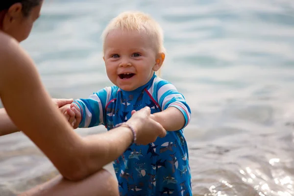 Słodki chłopiec maluch, grając na jeziorze. Gry w przyrodzie — Zdjęcie stockowe
