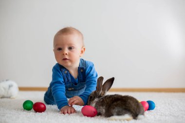 Bunnies ve Paskalya ile oynayan küçük yürümeye başlayan çocuk, bebek çocuk, 