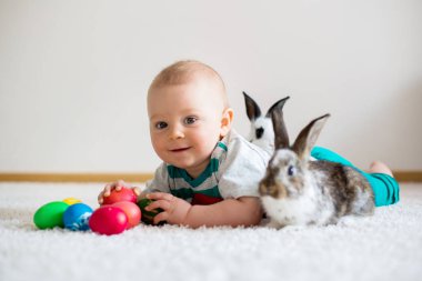 Bunnies ve Paskalya ile oynayan küçük yürümeye başlayan çocuk, bebek çocuk, 