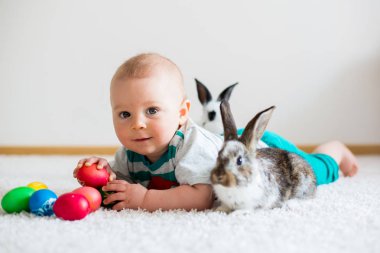 Bunnies ve Paskalya ile oynayan küçük yürümeye başlayan çocuk, bebek çocuk, 