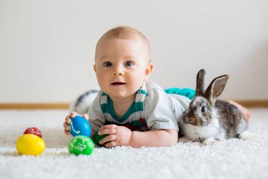 Bunnies ve Paskalya ile oynayan küçük yürümeye başlayan çocuk, bebek çocuk, 