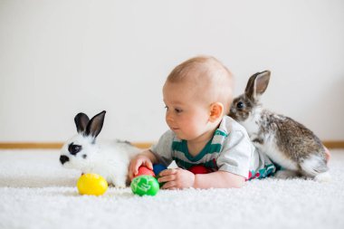 Bunnies ve Paskalya ile oynayan küçük yürümeye başlayan çocuk, bebek çocuk, 