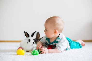 Bunnies ve Paskalya ile oynayan küçük yürümeye başlayan çocuk, bebek çocuk, 