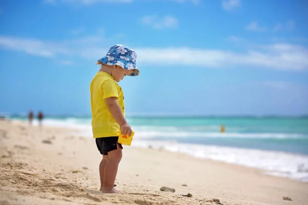 Lindo niño triste bebé jugando con juguetes de playa en la playa — Foto de Stock