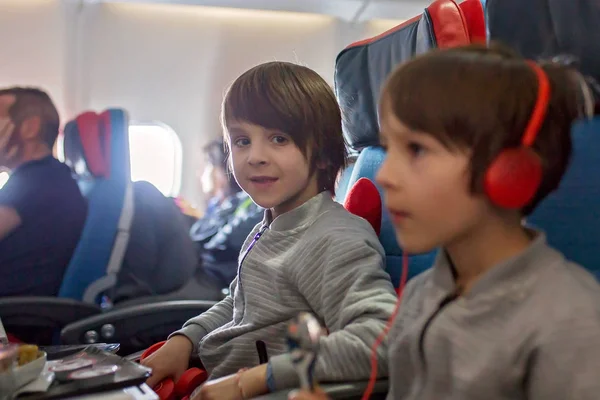 Bambino carino, ragazzo, guardando la TV a bordo degli aerei, viaggiando su — Foto Stock