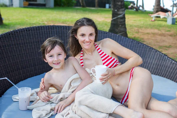 Leuke jongen, het drinken van Choco milkshake op het zwembad dek, terwijl op hol — Stockfoto