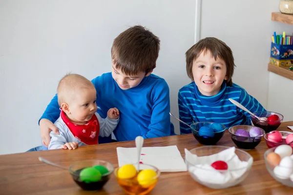 Tre bambini, fratelli, colorare e dipingere uova di Pasqua a h — Foto Stock