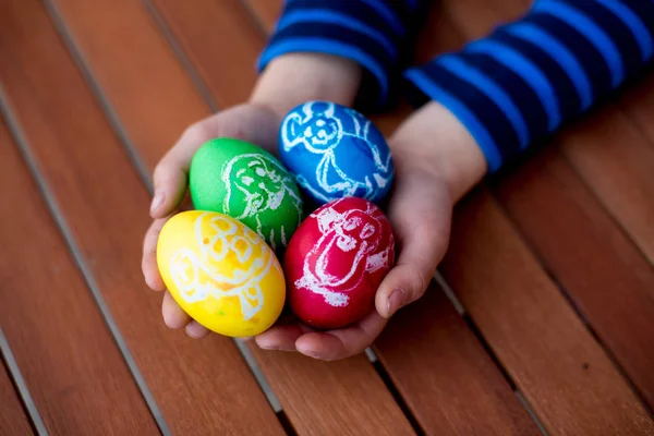 Uova di Pasqua colorate con disegni per bambini in mani di bambino — Foto Stock