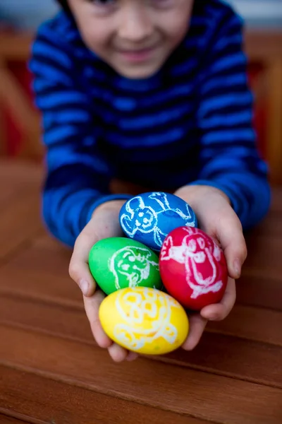 Красочные пасхальные яйца с детскими рисунками в детских руках — стоковое фото