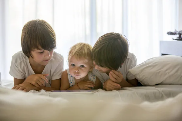 Frères, jouer au lit sur tablette, profiter des vacances d'été — Photo