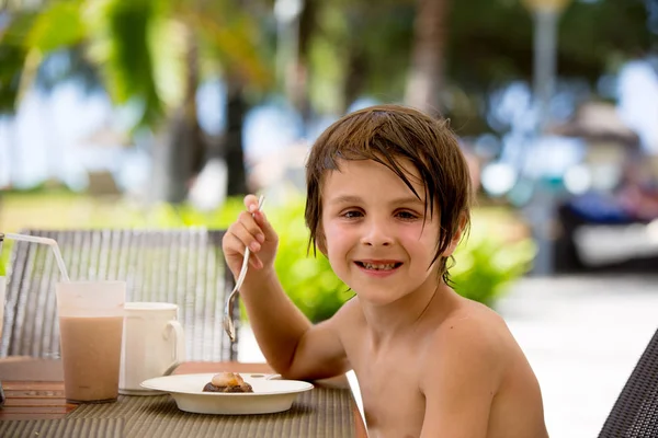 Dolce bambino in età prescolare, mangiare deserto in un ristorante sulla spiaggia summ — Foto Stock