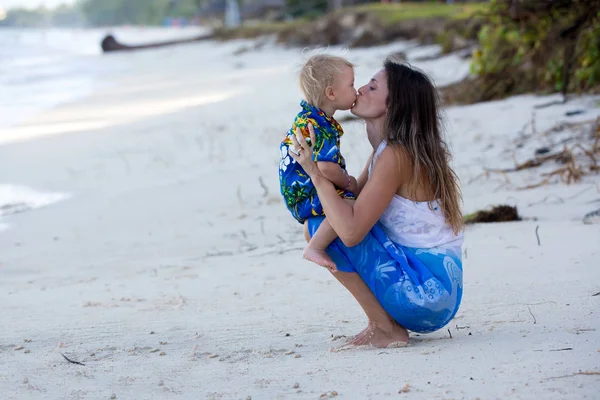 妈妈和蹒跚学步的男孩，愉快地拥抱在海边，放松 — 图库照片