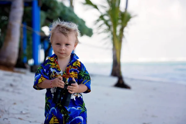 Sweet Boy kijkt door een verrekijker, observerend het oceaan leven een — Stockfoto