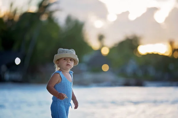Mignon tout-petit garçon sur la plage au coucher du soleil, magnifique beac tropical — Photo