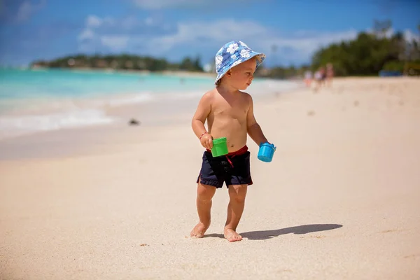 Lindo bebé jugando con juguetes de playa en la playa tropical — Foto de Stock