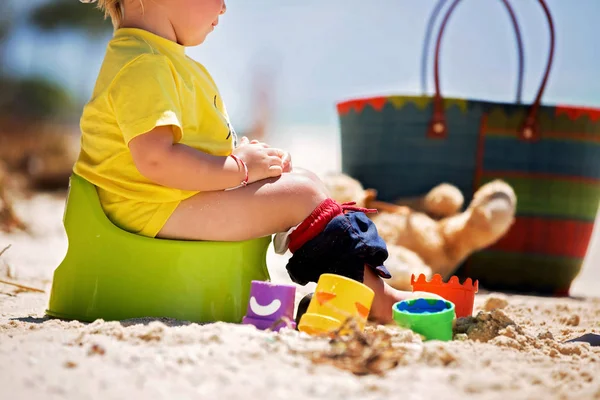Pequeño niño, aprendiendo el entrenamiento de orinal en la playa en un tr — Foto de Stock