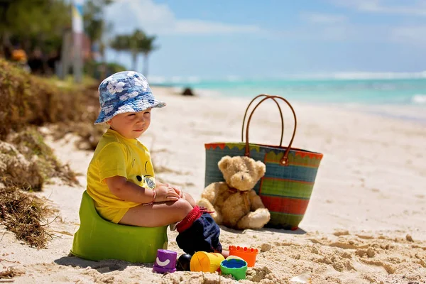 Pequeño niño, aprendiendo el entrenamiento de orinal en la playa en un tr — Foto de Stock