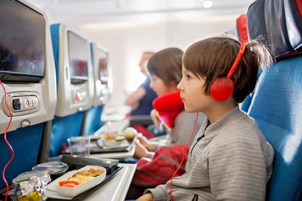 Bambino carino, ragazzo, guardando la TV a bordo degli aerei, viaggiando su — Foto Stock