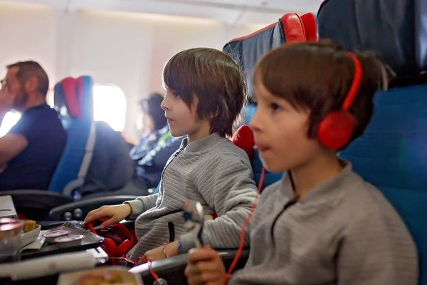 Bambino carino, ragazzo, guardando la TV a bordo degli aerei, viaggiando su — Foto Stock