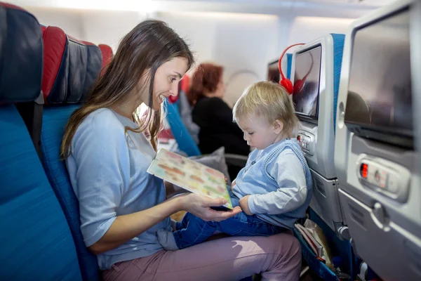Madre, intrattenere il piccolo bambino a bordo di aerei su — Foto Stock