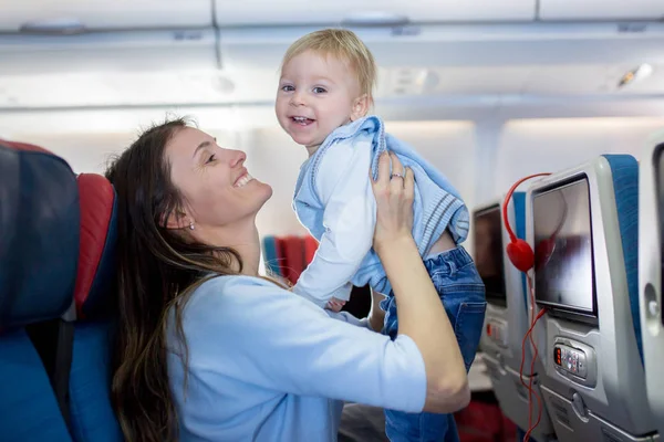 Madre, intrattenere il piccolo bambino a bordo di aerei su — Foto Stock