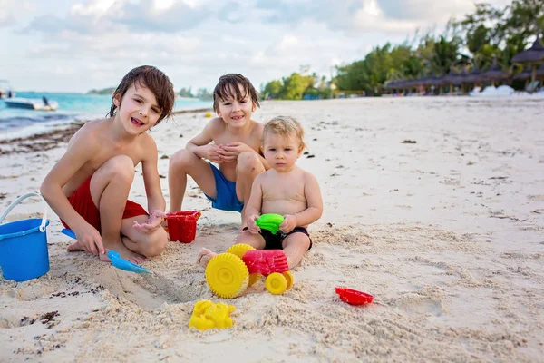 Aranyos kisfiú játszik beach játékokkal trópusi tengerparton — Stock Fotó