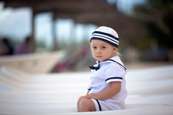 Bellissimo bambino ragazzo, vestito da marinaio, che gioca sulla spiaggia — Foto Stock