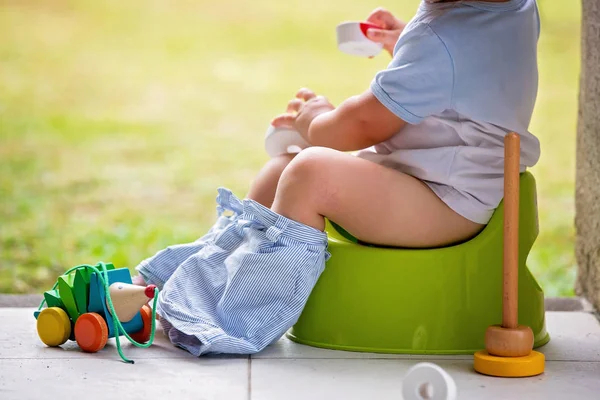 Doux tout-petit garçon, assis sur le pot sur un porche arrière en vacances — Photo