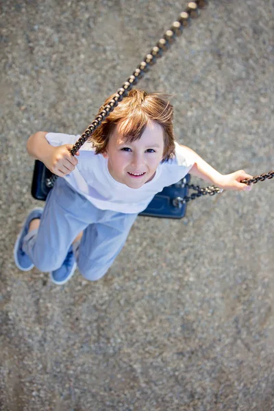 Bambino che oscilla nel parco giochi — Foto Stock