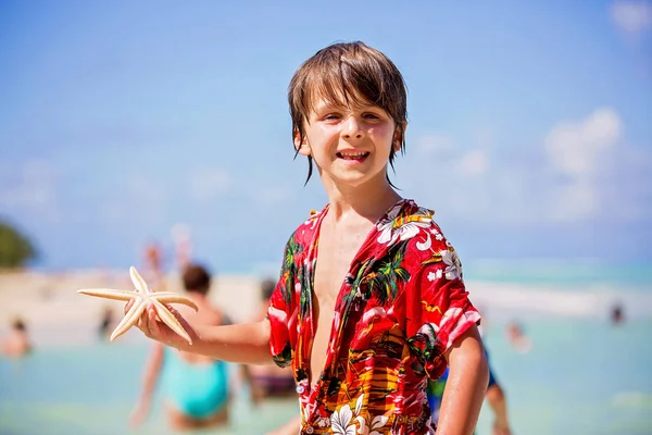 Niños jugando con estrellas de mar, niños felicidad playa verano conc — Foto de Stock