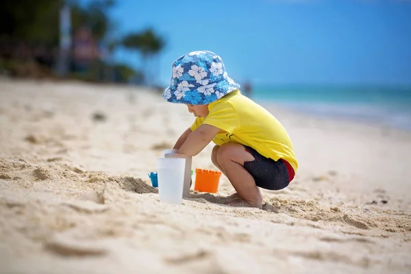 Lindo bebé niño jugando con juguetes en la playa tropical — Foto de Stock