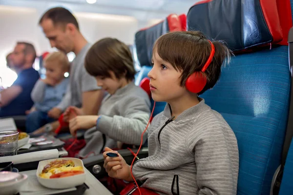 Söt barn, pojke, titta på TV ombord på flyg plan, reser på — Stockfoto