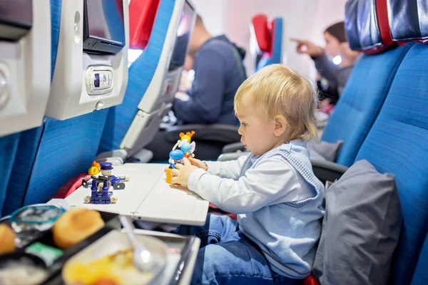 Bambino carino, ragazzo, giocare con i giocattoli a bordo di aeromobili, traveli — Foto Stock