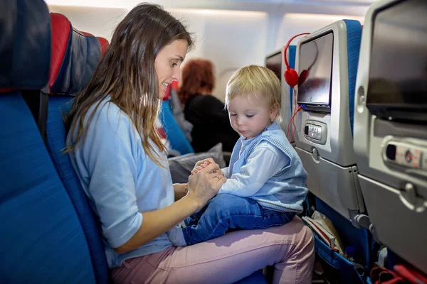 Madre, intrattenere il piccolo bambino a bordo di aerei su — Foto Stock