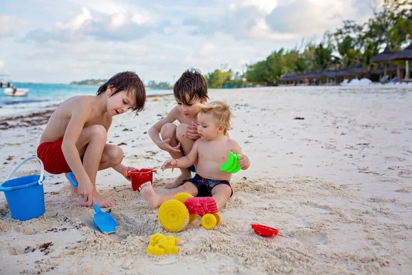 Lindo bebé jugando con juguetes de playa en la playa tropical — Foto de Stock