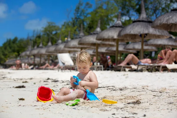 Lindo bebé niño jugando con juguetes de playa en la playa tropical — Foto de Stock