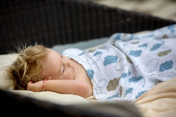 Χαριτωμένο ξανθό νήπιο Boy, κοιμάται σε ένα μεγάλο στρογγυλό καρέκλα παραλία σε t — Φωτογραφία Αρχείου