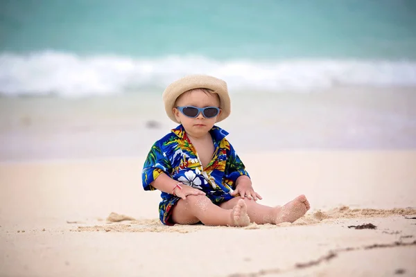 Lindo bebé niño jugando con juguetes de playa en la playa tropical —  Fotos de Stock