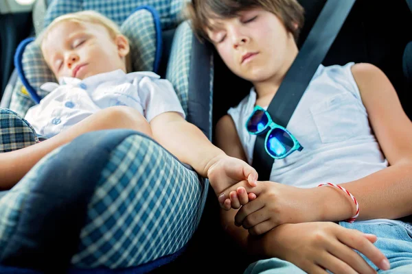 Kinder, die auf Reisen in Autositzen schlafen — Stockfoto