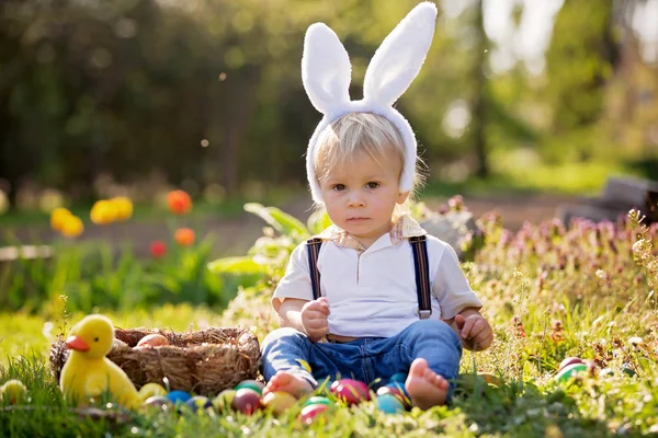 Zoete peuter jongen met bunny oren, eieren jagen voor Pasen, kind — Stockfoto