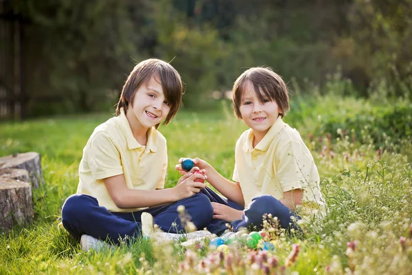 Sweet children, boy brothers with bunny ears, egg hunting for Ea — Stock Photo, Image