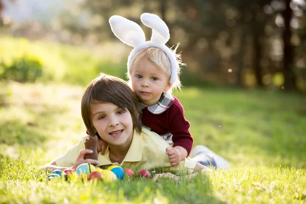 Dolci bambini, fratellini con le orecchie da coniglio, caccia alle uova per Ea — Foto Stock