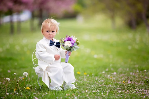 Hermoso niño, vestido con esmoquin blanco, sosteniendo hermosa — Foto de Stock