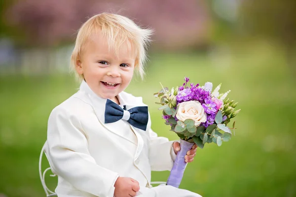 美丽的幼儿男孩，穿着白色燕尾服，拿着华丽 — 图库照片