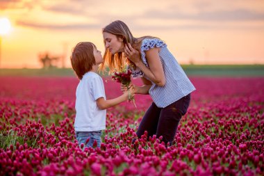 Kırmızı yonca alanında güzel anne ve oğlu, anne bo alıyorum