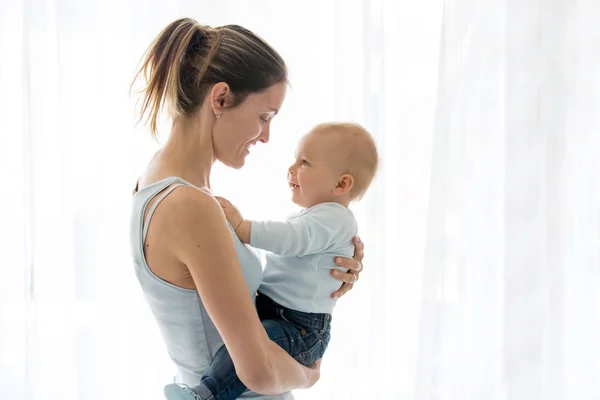 Madre joven, abrazando con ternura y cuidando a su bebé, s — Foto de Stock