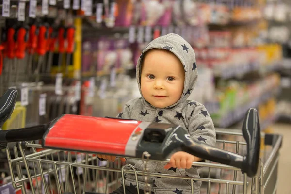 Kleinkind Baby Junge, sitzt in einem Einkaufswagen in Lebensmittelgeschäft, s — Stockfoto